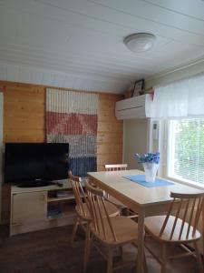 jadalnia ze stołem, krzesłami i telewizorem w obiekcie RISTIMÄENKATU 13 w mieście Savonlinna