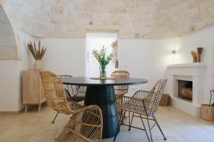 a dining room with a round table and chairs at Trullo Natù in Alberobello