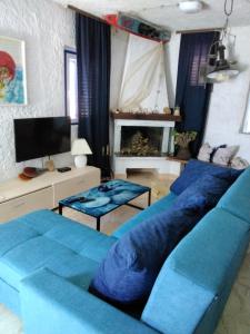 a living room with blue couches and a tv at House Kapetan Nono in Drače