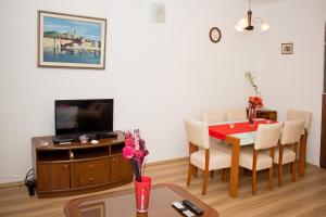 a living room with a dining room table and a television at Apartment Leatoni in Split