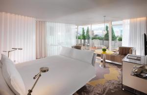 a bedroom with a white bed and a living room at Sanderson London in London