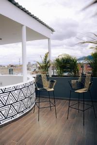 twee stoelen en een tafel op een dak bij Estainn Hotel Coworking in Bogota