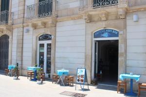 a restaurant with blue tables and chairs outside of a building at Casa Minniti in Syracuse