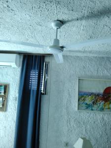 a ceiling fan and a window with a curtain at House Kapetan Nono in Drače