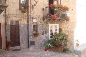 a building with flower boxes on the windows and a door at Marianna in Isnello