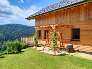 Cabaña de madera con porche y columpio en Auszeit Almhaus Schmalzbauer, en Sankt Andrä