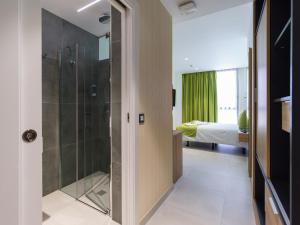 a bathroom with a shower and a bedroom with a bed at Hotel MG Poniente in Las Palmas de Gran Canaria