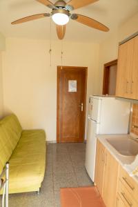 a kitchen with a ceiling fan and a refrigerator at Nikos Apartments in Ormos Panagias