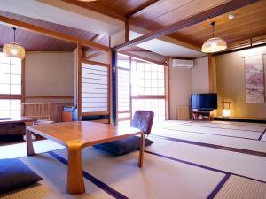 Sumiyosiya Ryokan في نوزاوا أونسن: غرفة معيشة مع طاولة وتلفزيون