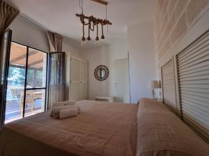 a bedroom with a large bed with a large window at Casa Armonia in Favignana