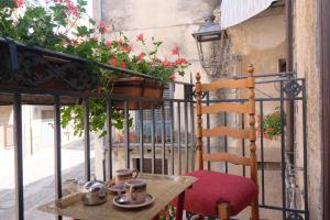 a table and a chair on a balcony with flowers at Marianna in Isnello