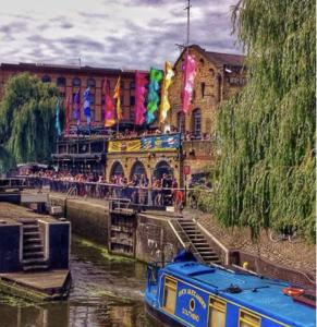 um barco em um rio ao lado de um edifício em Camden Apartments em Londres