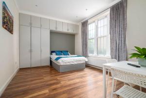 Schlafzimmer mit einem Bett und einem Tisch in der Unterkunft Camden Apartments in London