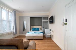 Un dormitorio con una cama con almohadas azules. en Camden Apartments en Londres