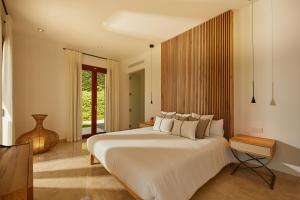 Un dormitorio con una gran cama blanca y una ventana en Villa Ruby by Cap Vermell Estate, en Canyamel