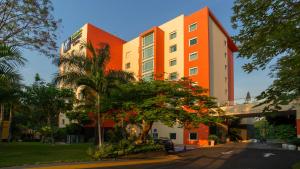 un edificio blanco y naranja con árboles delante de él en Holiday Inn Express & Suites Cuernavaca by IHG, en Cuernavaca