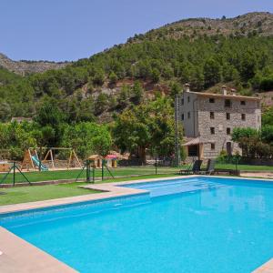 a swimming pool in front of a building with a mountain at El Molinet del Governador in Guadalest