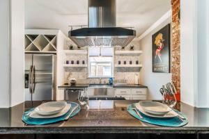 a kitchen with a counter with plates on it at Capitol Library-historic elegance cool & comfy in Oklahoma City