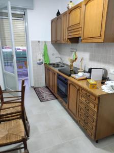 - une cuisine avec des placards en bois et un comptoir dans l'établissement Casa vacanze ferro, à Trapani