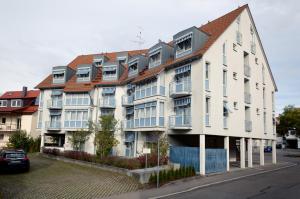 ein großes weißes Gebäude mit rotem Dach in der Unterkunft Akzent Hotel Torgauer Hof in Sindelfingen