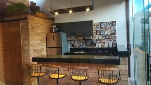 a kitchen with a bar with stools and a counter at Loft Antunes in Maricá