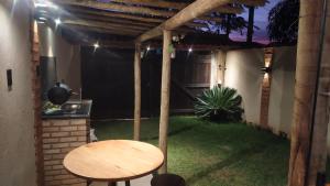 a patio with a wooden table and a table and a chair at Loft Antunes in Maricá
