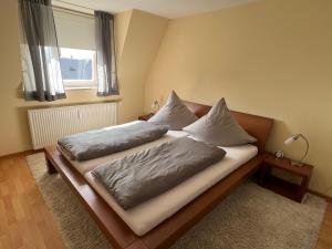 ein Bett mit zwei Kissen darauf in einem Schlafzimmer in der Unterkunft Sandwallkoje in Wyk auf Föhr