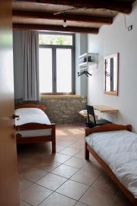 um quarto com 2 camas, uma secretária e uma janela em La Vrata Gialla em Taipana
