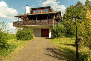 a house with a balcony and a walkway at Blockhaus Eifelsteig w/ Kamin Garten & Feuerstelle in Berndorf