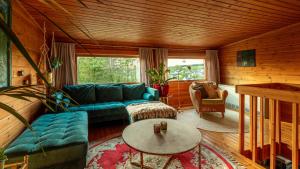 a living room with a blue couch and a table at Blockhaus Eifelsteig w/ Kamin Garten & Feuerstelle in Berndorf