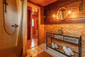 a bathroom with a shower and a shelf with towels at Blockhaus Eifelsteig w/ Kamin Garten & Feuerstelle in Berndorf +13 photos
