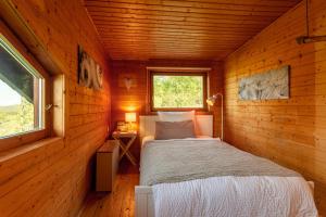 a small bedroom with a bed in a wooden cabin at Blockhaus Eifelsteig w/ Kamin Garten & Feuerstelle in Berndorf