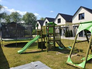a playground with a slide and a swing set at Apartamenty Wiślany Przekop in Gdańsk