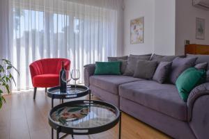 a living room with a couch and a red chair at Apartments Danijela & Love Nest in Rijeka