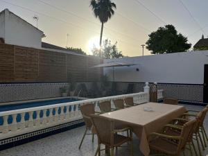 un patio con mesa, sillas y piscina en casa grande en Córdoba, pueblo de la Victoria , 6 dormitorios en La Victoria