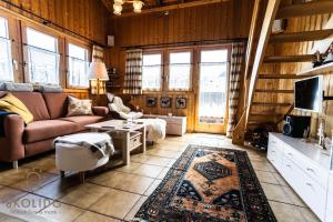 een woonkamer met een bank en een tv bij Chalet Aletschji, 3987 Riederalp, 2. Stock in Riederalp