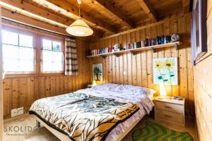 a bedroom with a bed in a wooden wall at Chalet Aletschji, 3987 Riederalp, 2. Stock in Riederalp
