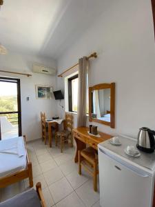 a room with a kitchen and a dining room with a table at Archontika Apartments in Kerames