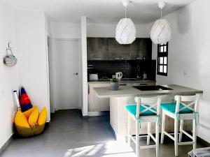 a kitchen with a counter and two stools in a room at Casita Vito Fuerteventura in Costa Calma