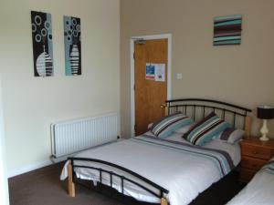 a bedroom with a bed and two pictures on the wall at The Balmoral & Terrace Guest Houses in Sunderland