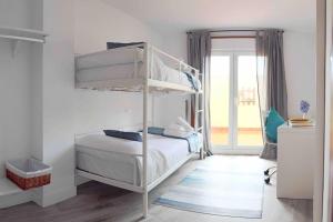 sypialnia z 2 łóżkami piętrowymi i oknem w obiekcie Apartamento Rosalía w mieście Isla de Arosa