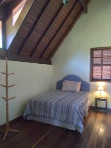 a bedroom with a bed in a room with a window at O Refúgio Colonial in Nova Friburgo