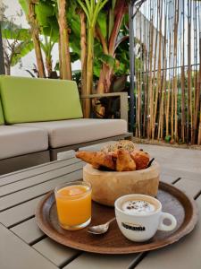 una mesa con una bandeja de pan y dos tazas de café en Chambres d'hôtes - Bed and Breakfast Les Palmiers en Mèze