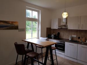 a kitchen with a table and chairs and a window at Sommerhaus (am Landhaus von Felde) in Esens
