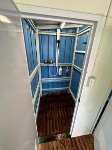 a walk in shower with a blue wall at 黑背包 Black Backpack 艙房式背包床 in Xiaoliuqiu +17 photos