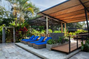eine Terrasse mit blauen Liegestühlen unter einem Pavillon in der Unterkunft Noah's Forest Hotel by Tifakara in Fortuna