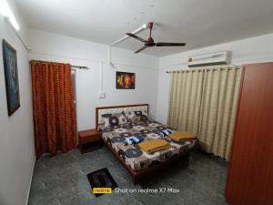 a bedroom with a bed and a ceiling fan at Palolem Sunrise Apartment in Palolem