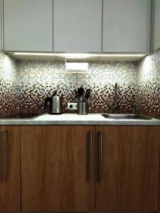 a kitchen with wooden cabinets and a sink at Neat and cosy in Riga +28 photos