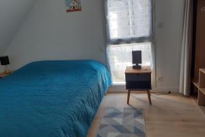 a bedroom with a bed and a table and a window at Maison Tamaris avec jardin et clos in Quiberon