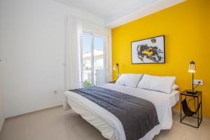 um quarto com uma cama grande e uma parede amarela em Esquina Soleada em Ciudad Quesada